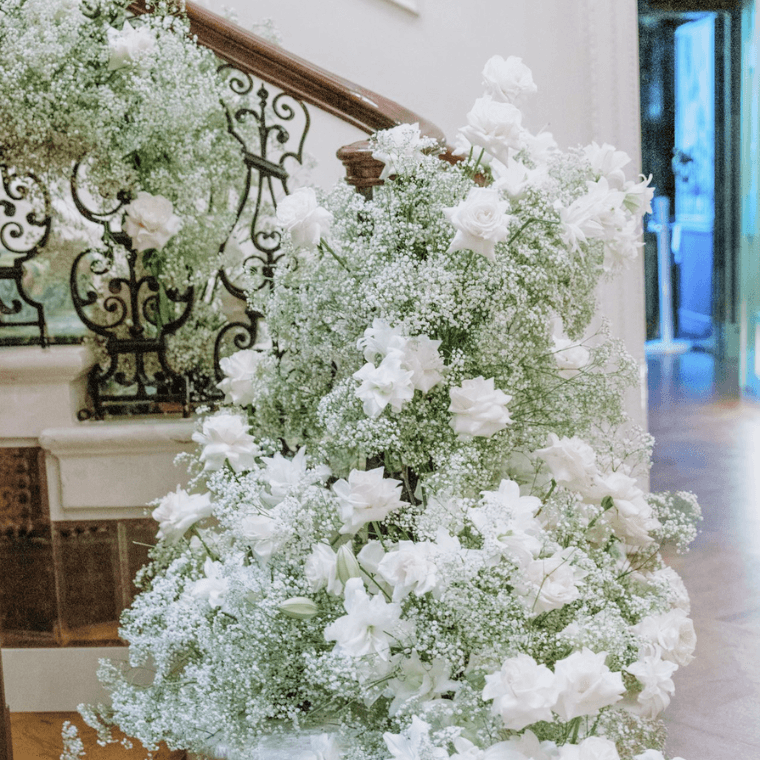 White roses, roselilies, and baby's breath decorating a staircase