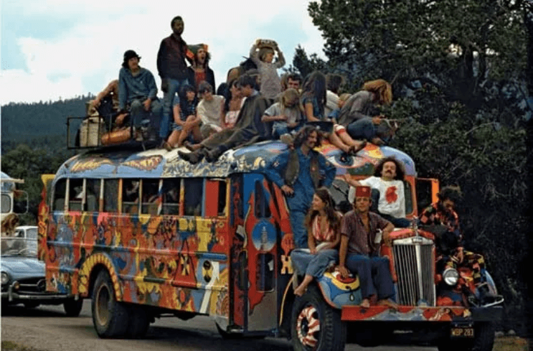 A brightly coloured buss with hippies sitting on top