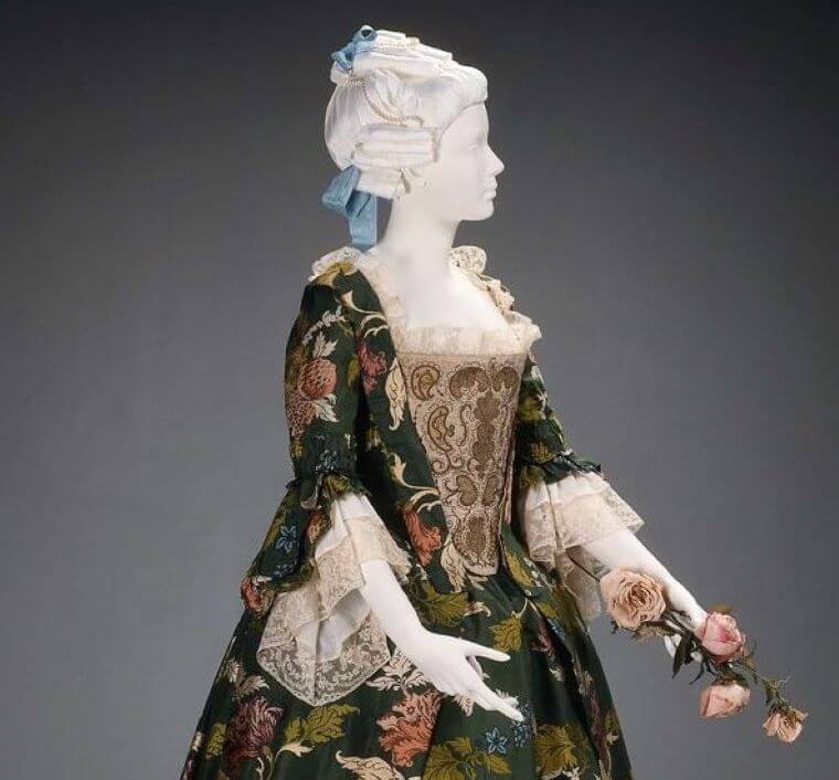 A statue wearing a floral brocade dress from the 18th century