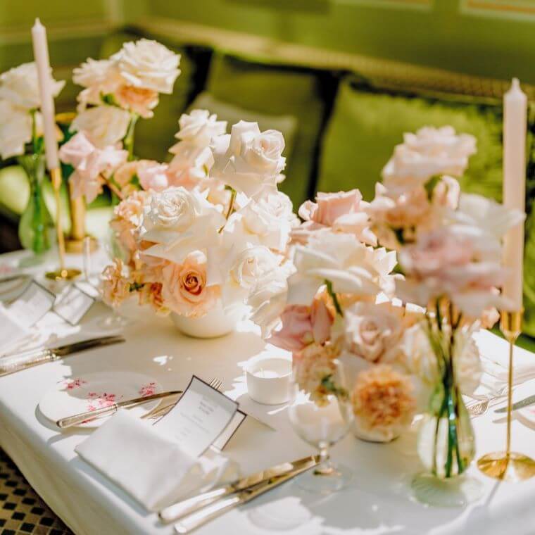 A table setting with pale pink and cream flowers by blooming haus
