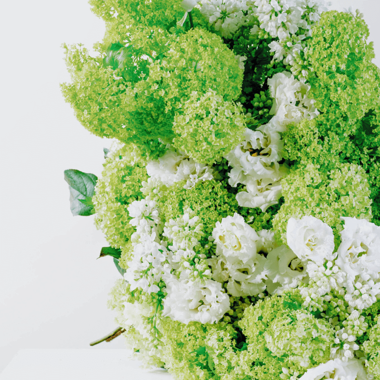 Green and white bouquet with  viburnum, lisianthus, and lilac.