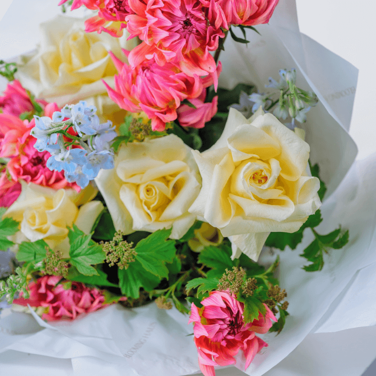 Mixed colour bouquet of delphiniums, roses, and pink dahlias