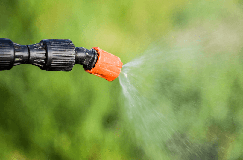 A nozzle with weedkiller spraying from it