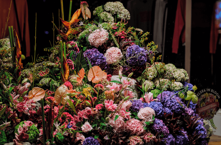 A large free-standing floral display with flowers of colours including purple, pink, orange, and green