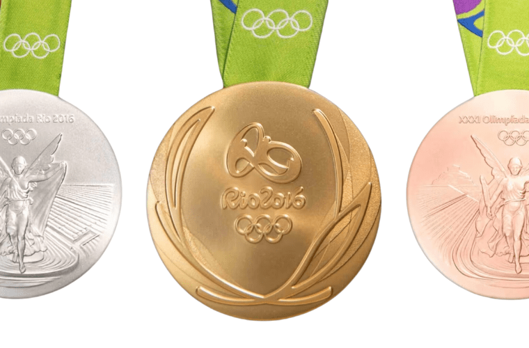 Three rio 2016 olympic medals are displayed: a silver medal on the left, a gold medal in the center, and a bronze medal on the right. All medals hang from green ribbons featuring the olympic rings and adorned with intricate designs. "rio 2016" and the olympic rings are prominently inscribed on them.