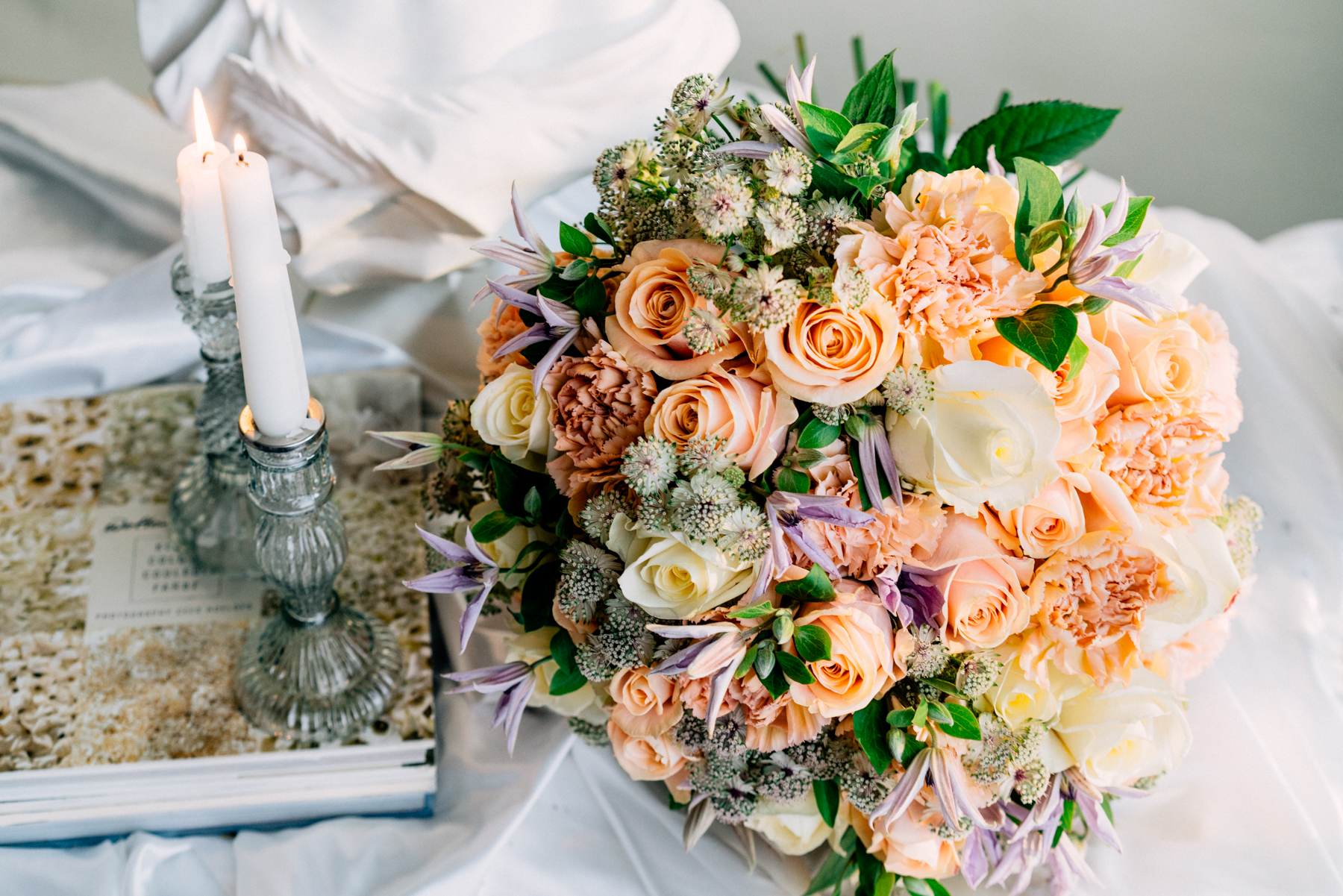Peach avalanche roses, purple clematis, white avalanche roses and astrantias round bouquet
