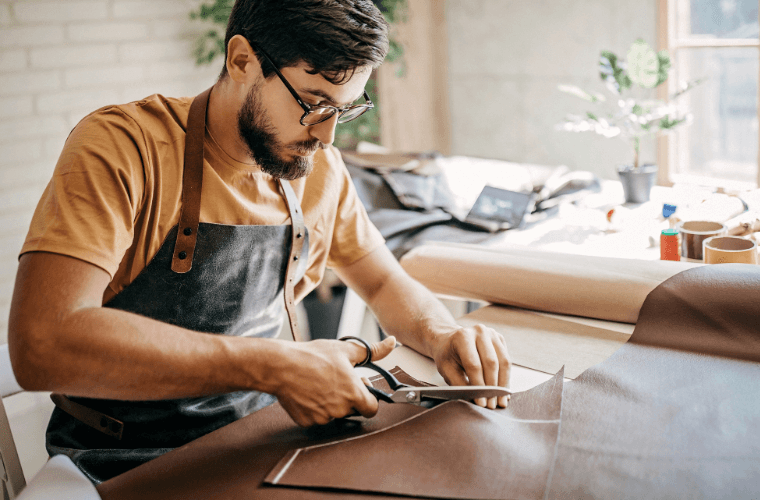 A man sat cutting material