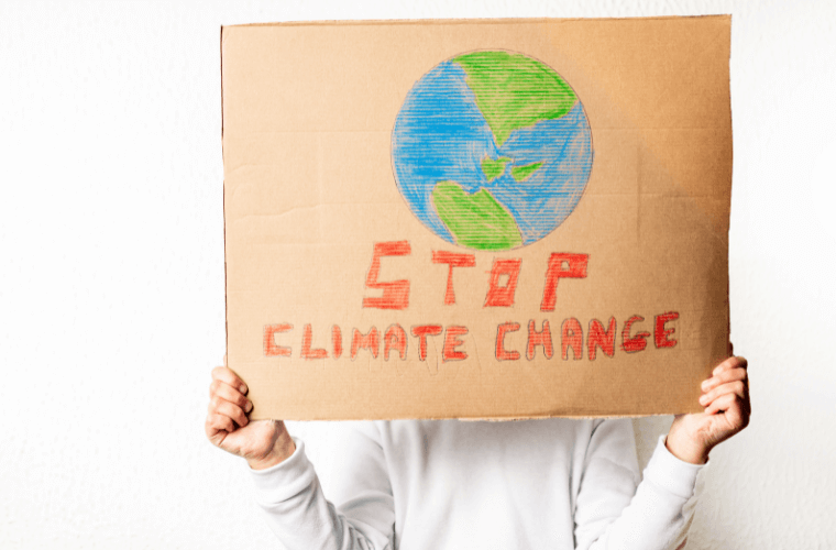 A person holding a sign with a picture of the earth and a the words atop climate change