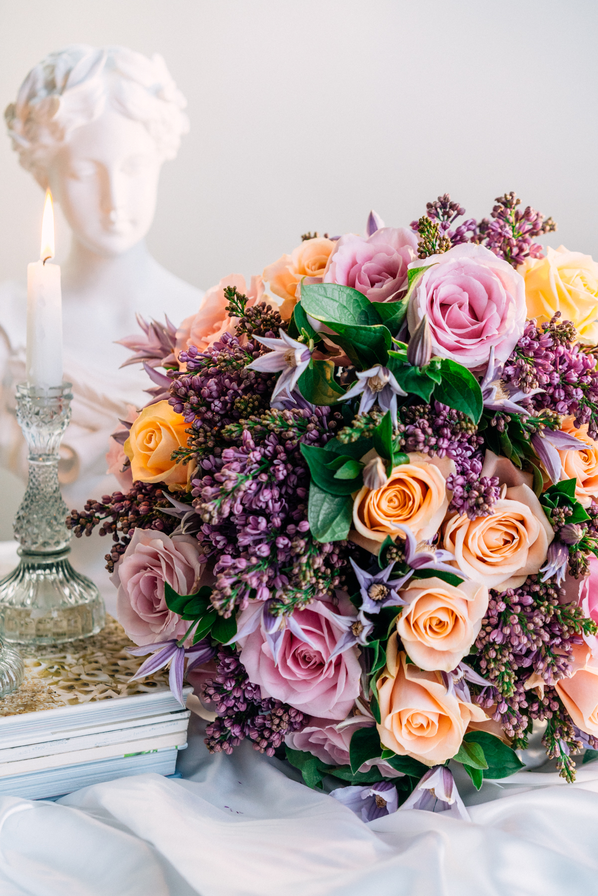 Purple lilac and peach avalanche roses round bouquet with clematis by blooming haus