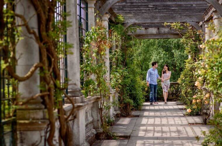 A couple walking hand in hand during a proposal at hampstead heath pergola