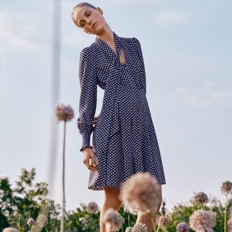A woman wearing a blue and white polka dot dress by me+em