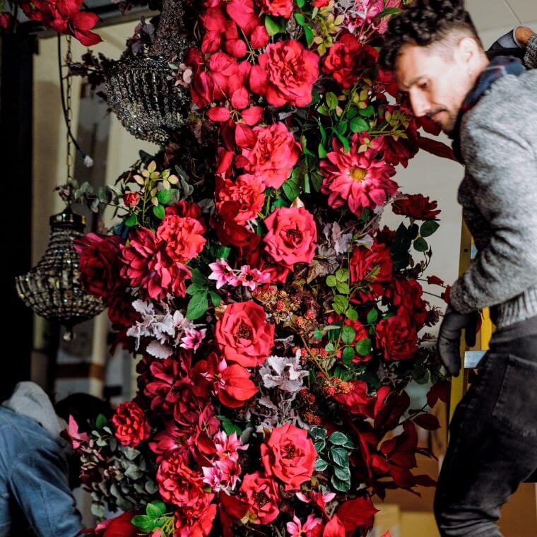Two blooming haus designers working on designing a flower arch