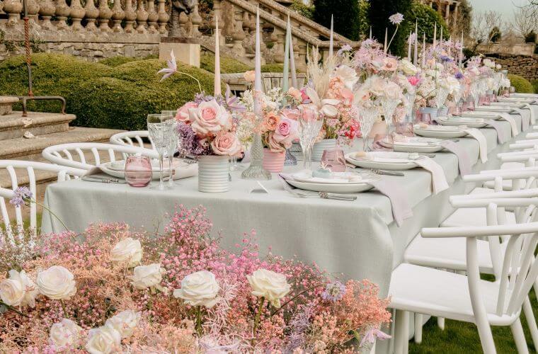 A wedding table decorated with candles and floral displays featuring roses