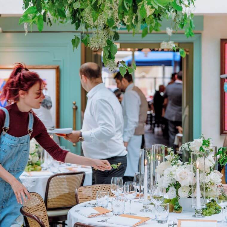A female florist putting then final touches to a floral table landscape