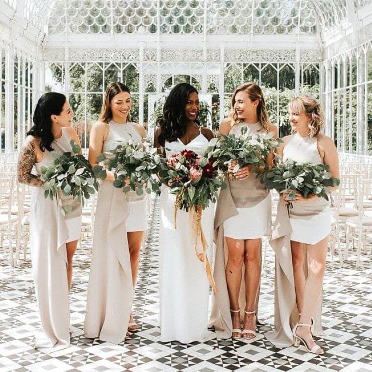 A bride and four bridesmaids with bouquets that mostly consist of foliage