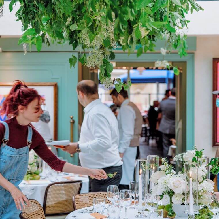 A female florist helping with table arrangements on the wedding day