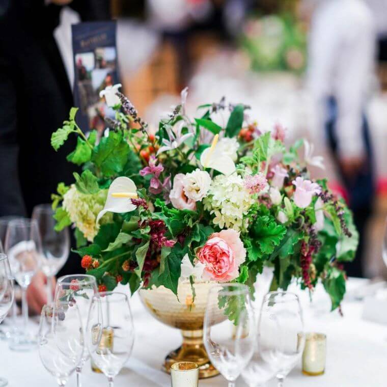 A table centrepiece with pink and white blooms together with a selection of green foliage