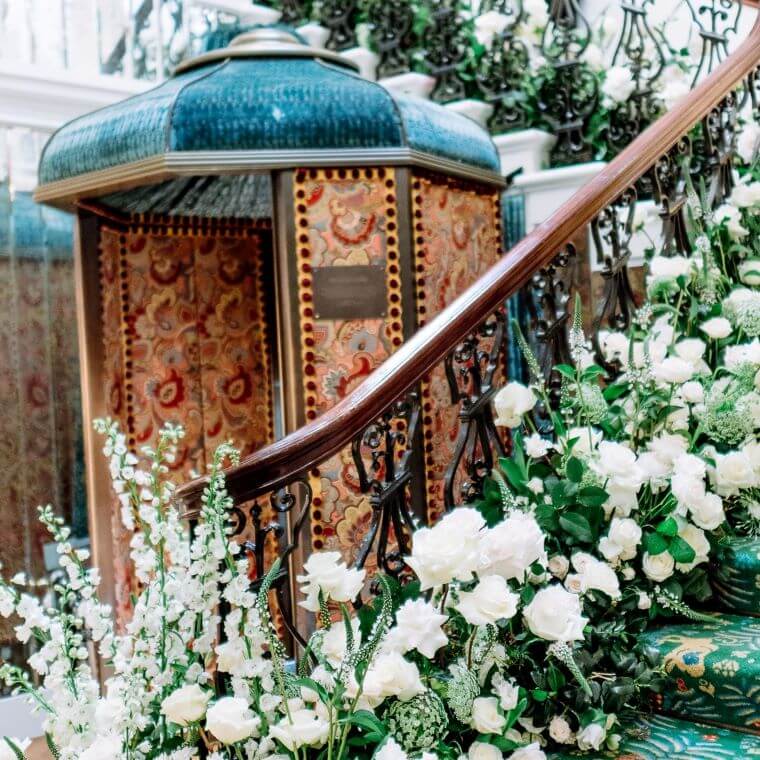 Large installation featuring white blooms and green foliage decorating a staircase