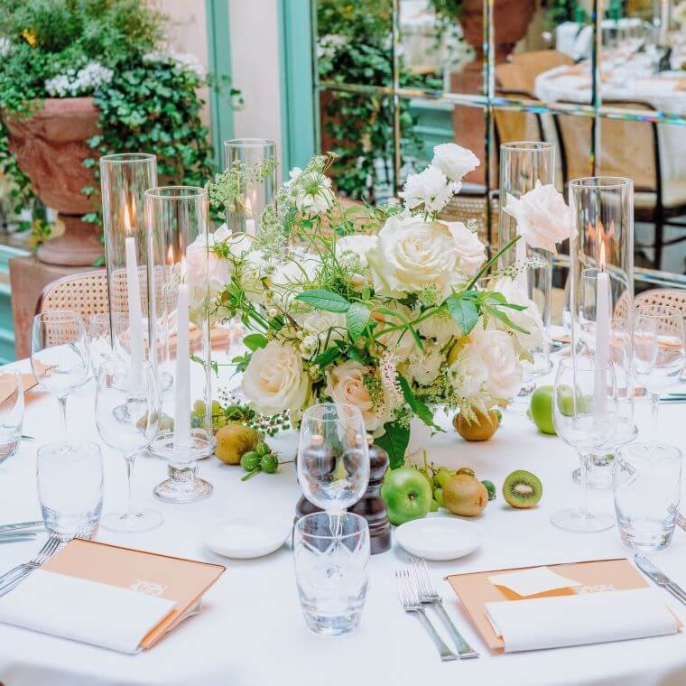 White and pale pink roses with foliage in a table centrepiece