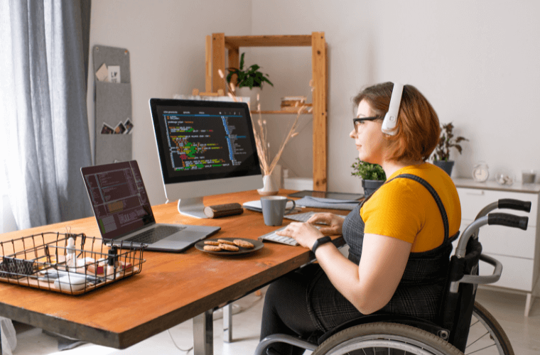 A woman in a wheelchair at a desk working from home