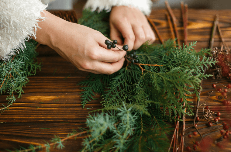 O woman's hands sorting foliage for a wreath